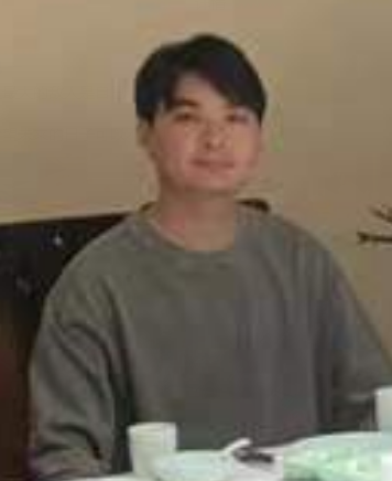 魏一坐在餐桌前的照片